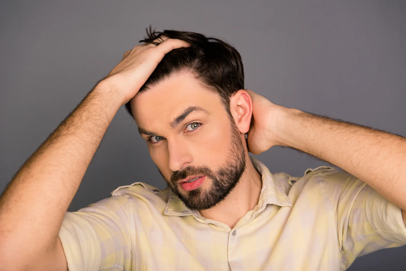 Man checking his hairline as part of a daily hair care routine